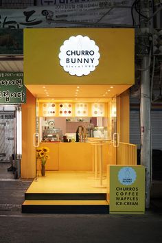 the entrance to a restaurant called churro bunny with yellow walls and steps leading up to it