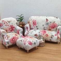 a living room with two chairs and a footstool in the middle of it