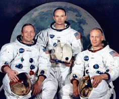 three men in white spacesuits are holding instruments and posing for a photo with the moon behind them