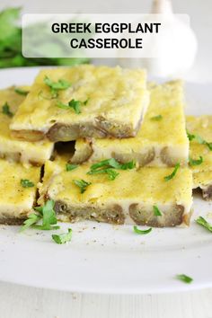 greek eggplant casserole on a white plate with green garnish