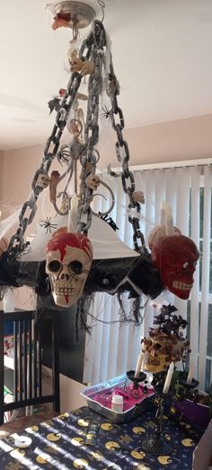 a dining room table with halloween decorations hanging from it's ceiling and on top of the table