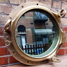 a porthole mirror on the side of a brick wall