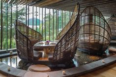 two wooden boats sitting in the middle of a room next to a table and chairs