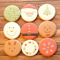 twelve decorated christmas cookies arranged on a wooden table