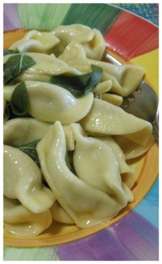 a yellow plate topped with dumplings covered in sauce