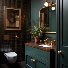 a bathroom with green cabinets and a white toilet next to a painting on the wall