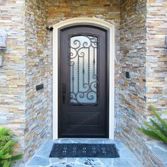 the front door to a home with stone walls and iron grills on it's sides