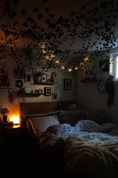 a dimly lit bedroom with lots of plants hanging from the ceiling and pictures on the wall