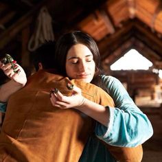 two women hug each other in an old barn