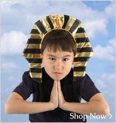 a young boy wearing an egyptian headdress with his hands folded in front of him