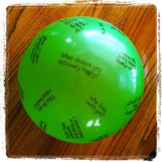 a green frisbee sitting on top of a wooden table with writing all over it