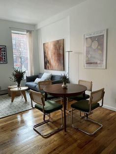 a living room filled with furniture and a table in front of a large painting on the wall