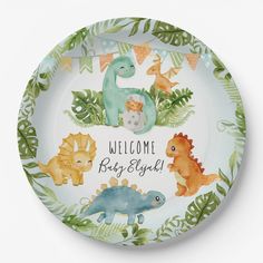 a plate with dinosaurs on it and the words welcome baby girl written in large letters