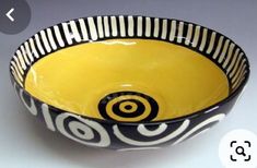 a yellow and black bowl sitting on top of a table