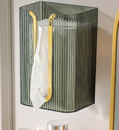 a green and yellow wall hanging on the side of a white wall next to a mirror