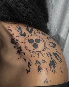 the back of a woman's shoulder with black ink on her body and hand prints