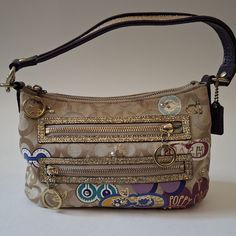 Vintage Coach Poppy Petal Line Canvas Hand Bag. The Base Color Is 2 Toned Brown With Coach Logo, Embellished With Colorful Patches And Studs. It Has A Purple Leather Handle With Gold Glittery Trim And Also Around The Two Front Zipper Pockets. Inside Is A Light Green Satin Lining. There Is No Damage Or Orders, But There Are A Couple Of Marks On The Back And The Inside Lining (See Photos). Coach Poppy, Coach Logo, Vintage Coach Bags, Canvas Purse, Vintage Coach, Fancy Bags, Purple Leather, Green Satin, Brown Gold