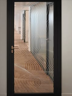 an open door with white lines on the glass and wood flooring in front of it