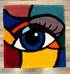 a rug with an eye painted on the front and side of it in multi - colored colors