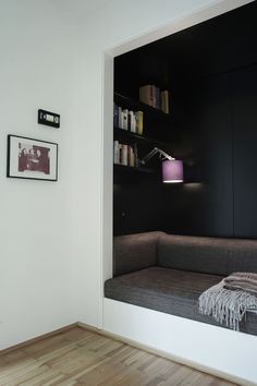 a living room with a couch and bookshelf next to a wall mounted book shelf