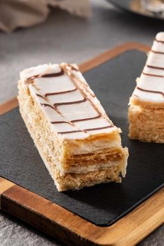 two pieces of cake sitting on top of a cutting board