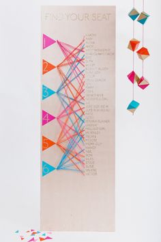 an advertisement for a wedding with colorful origami pieces hanging from the side of it