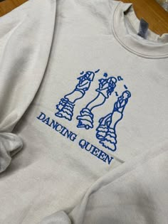 This sweatshirt/t-shirt/hoodie is embroidered to order. The size of the embroidery is approximately  17,000 stitches.  We have a range of size and colours to choose from but if you'd like a size/colour not advertised please contact us and I'll be more than happy to help.  Our average processing times are around 2/3 working days to have your order ready and then 2 days for delivery via Royal Mail. If you need the item sooner please simply contact us.  Any other questions please do not hesitate to Mama Mia Sweatshirt, Dancing Queen Shirt, Mamma Mia Merch, Hoodie Diy, Music Merch, Fancy Shirt, Queen Shirts, Embroidered Tote, Mama Mia