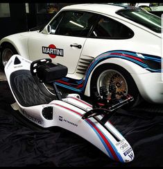 a white sports car parked in a garage next to a black tarp with the word martini on it