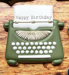 an old fashioned green typewriter with a happy birthday sign on it's side