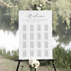 a sign that is sitting on top of a wooden stand with flowers and greenery