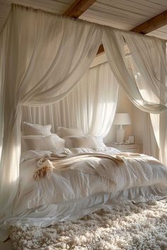 a bed with white sheets and curtains in a bedroom