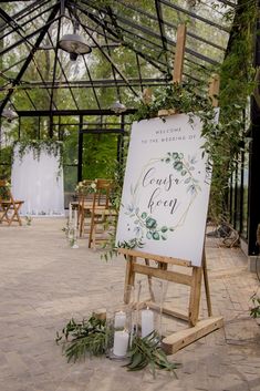 an easel with candles and greenery on it is set up for a wedding ceremony