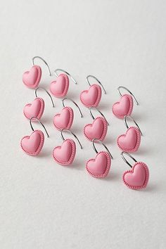 small pink heart shaped clips are on a white surface with clippings in the shape of hearts