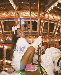 a woman sitting on top of a merry go round