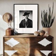 a black and white photo sitting on top of a wooden dresser