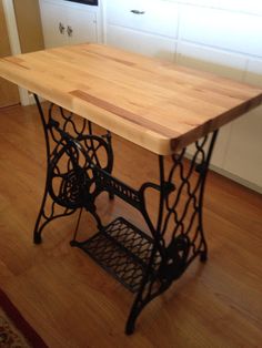 an old fashioned sewing machine sits on the floor in front of a kitchen countertop