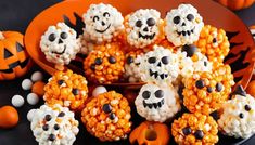 halloween popcorn balls with skulls and jack - o'- lanterns in the middle on an orange plate