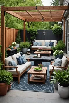 an outdoor living area with couches, tables and potted plants