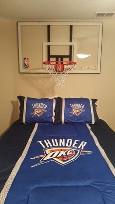 a basketball hoop hangs above the bed in this boys'bedroom with blue comforter and matching pillows