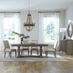 a dining room table with four chairs and a chandelier hanging from the ceiling