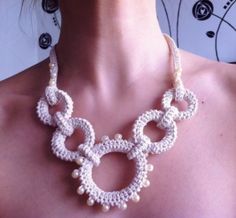 a woman wearing a white crocheted necklace