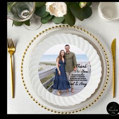 a plate with an image of a couple on it next to goldware and flowers