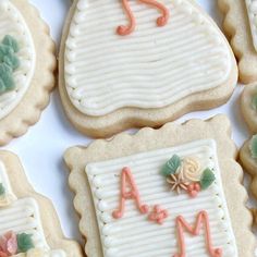 decorated cookies are arranged in the shape of letters, numbers and flowers on a white surface