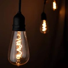 several light bulbs hanging from the ceiling in a dark room with lights on either side