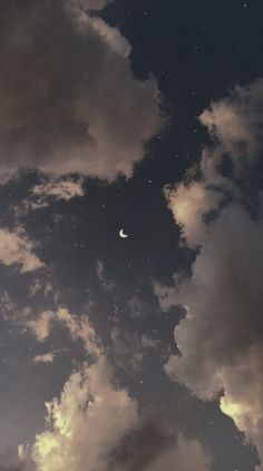 the sky is filled with clouds, and there is a half moon in the distance