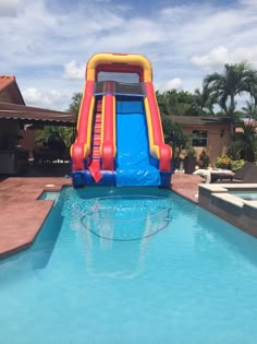 an inflatable water slide next to a swimming pool