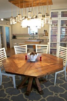 a wooden table with white chairs around it