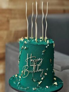 a green birthday cake with gold sprinkles on it