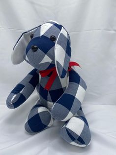 a blue and white stuffed animal with a red ribbon around its neck on a white background