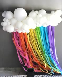 a bunch of balloons that are in the shape of a rainbow and white ballons